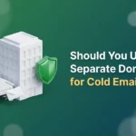 Large office building beside a small detached outbuilding with an envelope flying out and a green shield between them, illustrating a separate domain for cold email